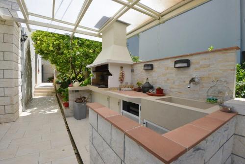 una cocina al aire libre con techo de cristal y fregadero en Villa Elly, en Dubrovnik