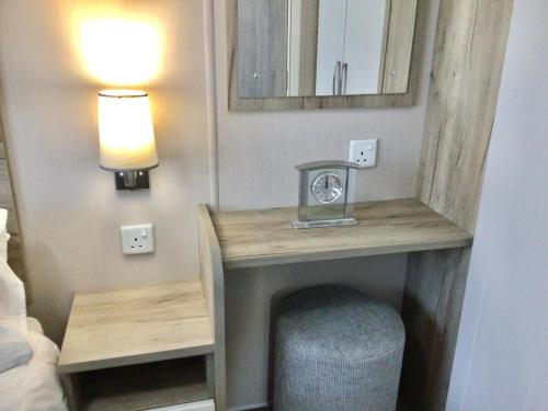 a room with a desk with a clock and a mirror at Luna Retreat - Newbiggin by the Sea in Newbiggin-by-the-Sea