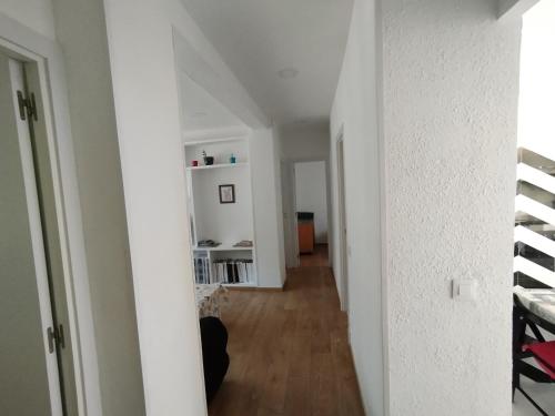 een hal van een appartement met witte muren en houten vloeren bij Apartamento luminoso y nuevo en Madrid Rio in Madrid