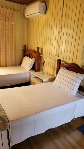 Zimmer mit 2 Betten und einem Waschbecken. in der Unterkunft Pousada 4 Estações in Lauro Müller
