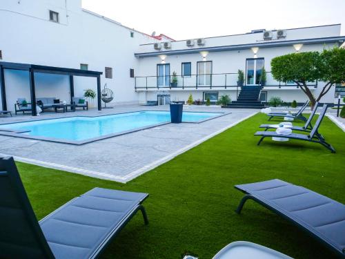 a building with a swimming pool and some lounge chairs at Maison de Julia Pompei in Pompei