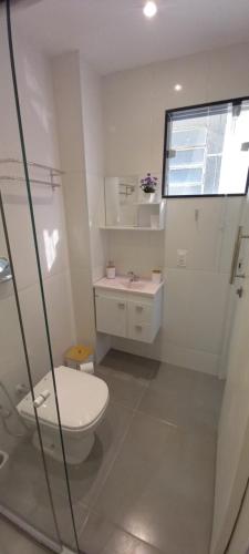 Baño blanco con aseo y lavamanos en Lindo apartamento na Lapa, en Río de Janeiro