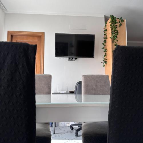 a conference room with a table and chairs and a tv at Vinciguerra Central House Tuscany in Altopascio