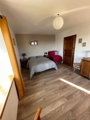 une chambre avec un lit et un parquet dans l'établissement Vue sur les Montagnes, à Lapoutroie