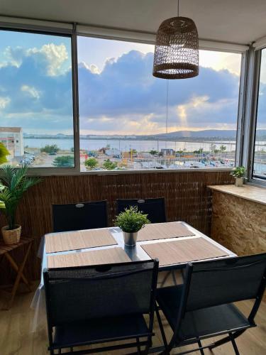 une salle à manger avec une table et une grande fenêtre dans l'établissement T2 climatisé à 100m de la plage, à Frontignan