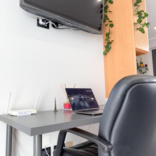 an office desk with a laptop and a chair at Vinciguerra Central House Tuscany in Altopascio