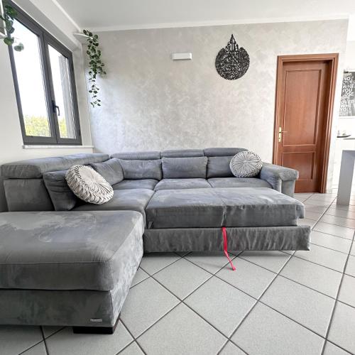 a living room with a gray couch at Vinciguerra Central House Tuscany in Altopascio