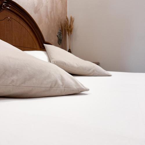 a bed with white sheets and pillows on it at Vinciguerra Central House Tuscany in Altopascio