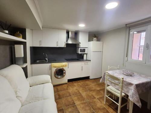 El Apartamento في Ateca: مطبخ مع أريكة وطاولة في الغرفة