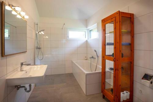 uma casa de banho com um lavatório, um espelho e uma banheira em Im Mondseeland em Innerschwand