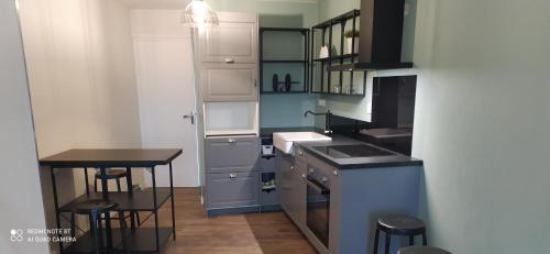 a small kitchen with a sink and a table at gite de La place de l'église in Sainte-Mère-Église