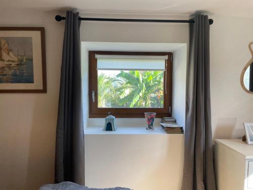 a window in the corner of a room with a curtain at Les gîtes d'Izel RDC in Ploemel