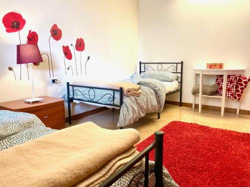 1 dormitorio con 2 camas y alfombra roja en Loft Bergamo Casa Vacanze, en Bérgamo