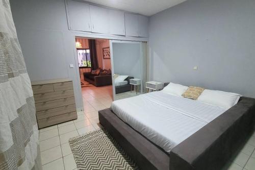 a bedroom with a bed and a living room at Villa Bonapriso avec piscine in Douala