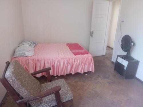 a bedroom with a bed and a chair and a dresser at Quarto com Duas Camas de casal in Vitória