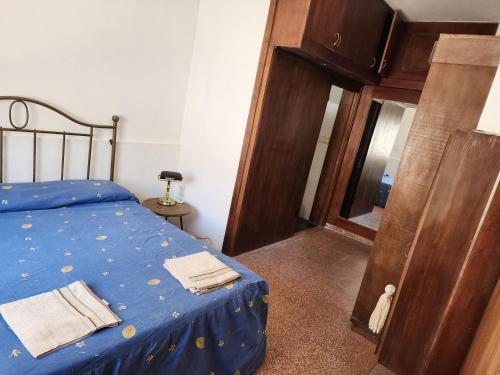 1 dormitorio con 1 cama azul y armario de madera en Hermosa vista, en Colonia del Sacramento