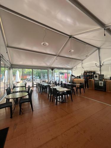 una zona pranzo con tavoli e sedie in tenda di Domaine Les Acacias a La Ville-aux-Dames