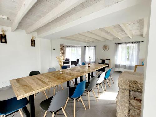 ein großes Esszimmer mit einem langen Tisch und Stühlen in der Unterkunft Gîte des Rondins in Aumontzey