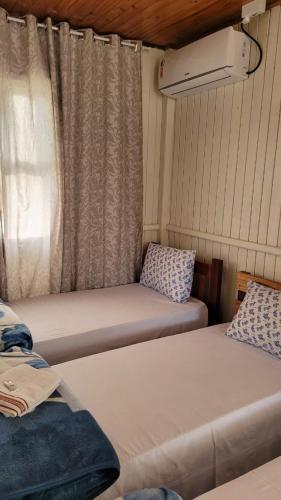 Pokój z 2 łóżkami i oknem z zasłonami w obiekcie 4Estações w mieście Lauro Müller