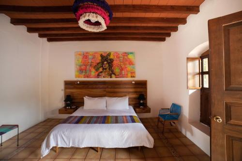 - une chambre avec un lit et une tête de lit en bois dans l'établissement NaNa Vida Hotel Oaxaca, à Oaxaca