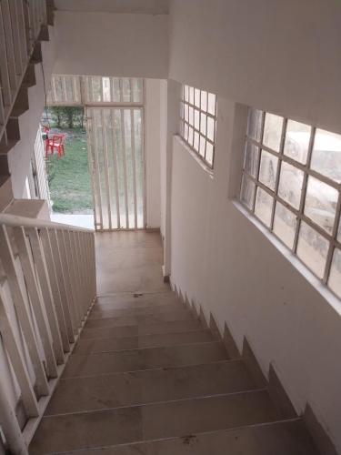 un pasillo vacío de una casa con escaleras y ventanas en White House Resort, 
