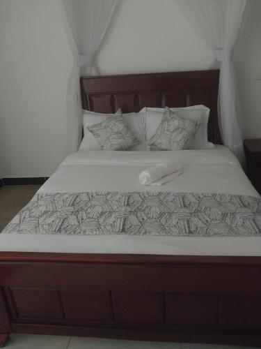 a bed with a wooden frame and white sheets and pillows at White House Resort 