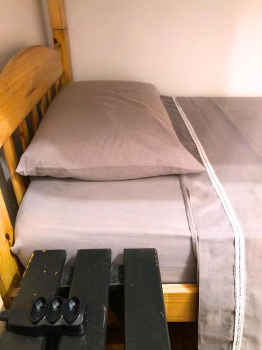 a small bed with a remote control next to it at Micasa Hostel - Congonhas in Sao Paulo