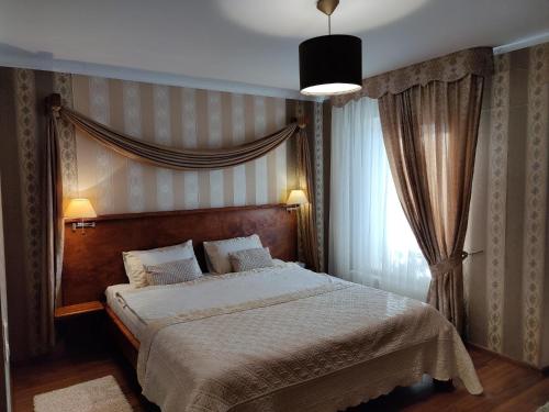 a bedroom with a large bed and a window at Motelis SMAKŲ SMAKAS in Šiauliai