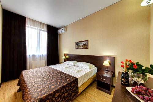 um quarto de hotel com uma cama e uma mesa com flores em Guesthouse Bella Vista em Gelendzhik