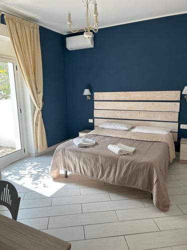 a blue bedroom with a bed with two towels on it at La Porta del mare SPA in Tropea