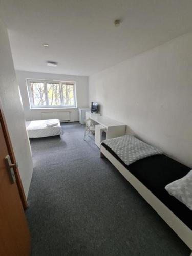 1 Schlafzimmer mit 2 Betten, einem Schreibtisch und einem Fenster in der Unterkunft Privat zimmer in Rostock