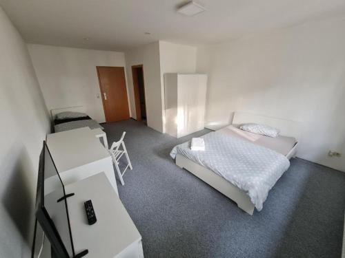 een slaapkamer met 2 bedden en een bureau. bij Privat zimmer in Rostock