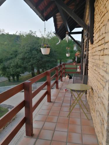 a wooden balcony with a table and a fence at Une halte aux portes de Bourgoin in Saint-Marcel-Bel-Accueil