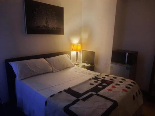 een slaapkamer met een bed met een zwart-wit dekbed bij A.B.C ROOM SERVICES in Garges-lès-Gonesse
