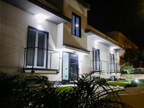a white building with blue doors and windows at night at Maison de Julia Pompei in Pompei