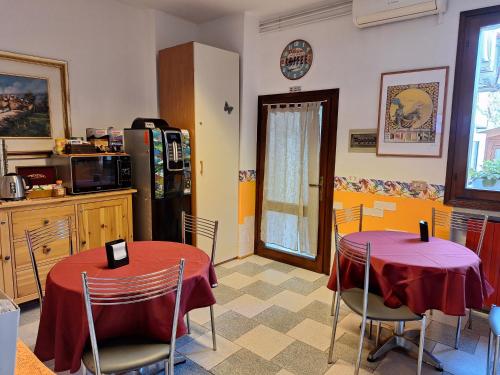 a kitchen with two tables and a refrigerator at Affittacamere Due Mori in Monselice