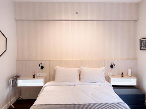 - une chambre avec un grand lit blanc et 2 tables dans l'établissement Suite Patio Paulista 06, à São Paulo