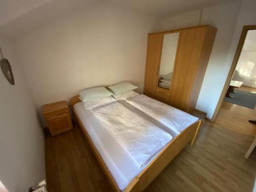 a small bedroom with a bed and a mirror at Apartman Željo in Livno