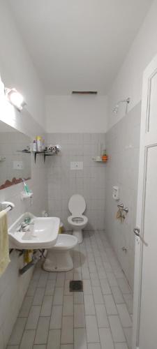 - une salle de bains blanche avec 2 toilettes et un lavabo dans l'établissement Habitación Privada en casa compartida para viajeros, à Córdoba