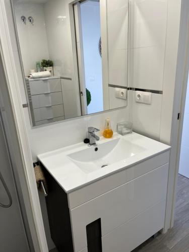 ein Badezimmer mit einem weißen Waschbecken und einem Spiegel in der Unterkunft Precioso apartamento en 1º Línea de playa in Benidorm