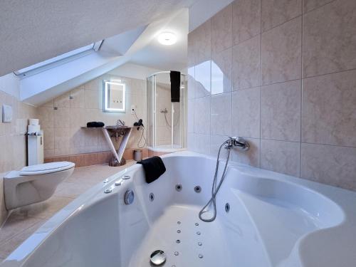 a white bath tub in a bathroom with a toilet at Alpha Apartments in Krefeld