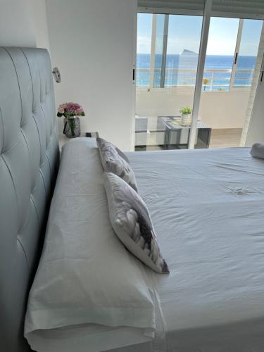 ein Kissen auf einem Bett mit Meerblick in der Unterkunft Precioso apartamento en 1º Línea de playa in Benidorm