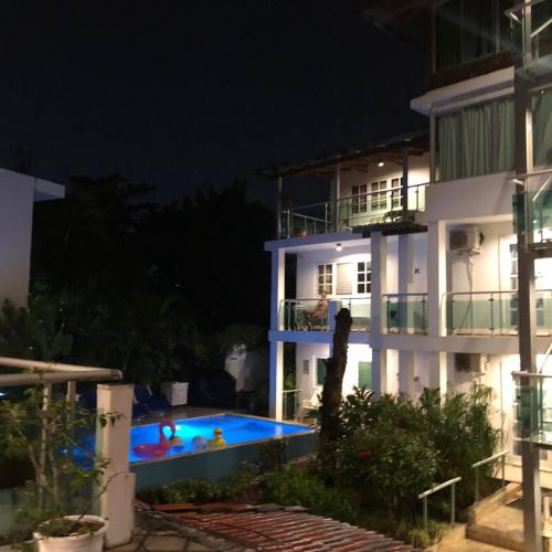 a villa with a swimming pool at night at Hotel Neptuno Refugio in Boca Chica