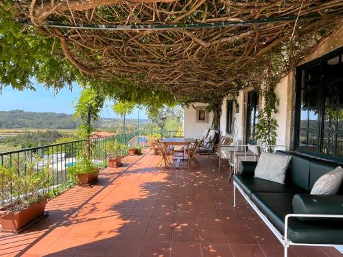 un patio con sofás y mesas en un balcón en Casa da Quinta do Outeiro, en Reveles