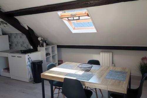 une cuisine avec une table et des chaises ainsi qu'une lucarne dans l'établissement Appartement F2 : entrée du Havre, au Havre