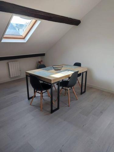 une table et des chaises dans une pièce avec une fenêtre dans l'établissement Appartement F2 : entrée du Havre, au Havre