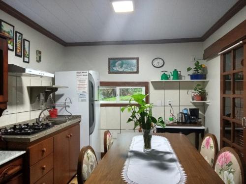 a kitchen with a table with a vase on it at CASA DA FAMÍLIA DE GRAMADO in Gramado