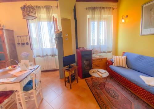 Una sala de estar con un sofá azul y una mesa. en Ca' Tomassino Holiday Apartments, en Urbino