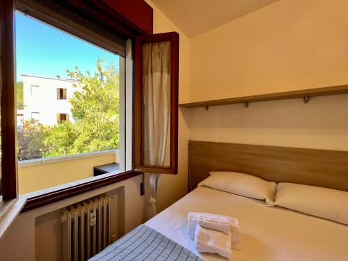 um quarto com uma cama e uma grande janela em All'ombra del Carmine em Pádua