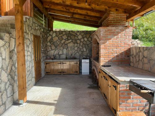 an outdoor kitchen with a stone wall at Vikendica Krupa na Vrbasu in Banja Luka